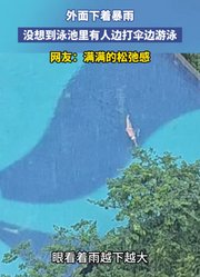 外面下着暴雨，没想到泳池里有人边打伞边游泳