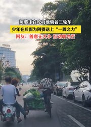 阿婆正在吃力地骑着三轮车，少年在后面为阿婆送上“一脚之力”。