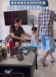 妹妹看到哥哥被抱着自己也想要，撵走哥哥后坐到奶奶怀里。