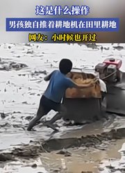 男孩独自推着耕地机在田里耕地